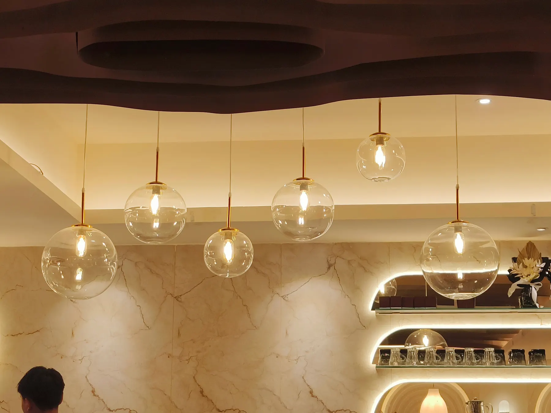 Glass globe pendant lights hanging over a bright modern interior